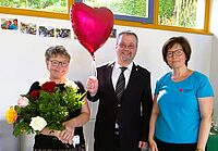 Wilfriede Frank steht neben DRK-Geschäftsführer Christian Peter und Nachfolgerin Sabrina Baier. Frau Frank hält einen Blumenstrauß, Herr Peter einen Herz-Luftballon.
